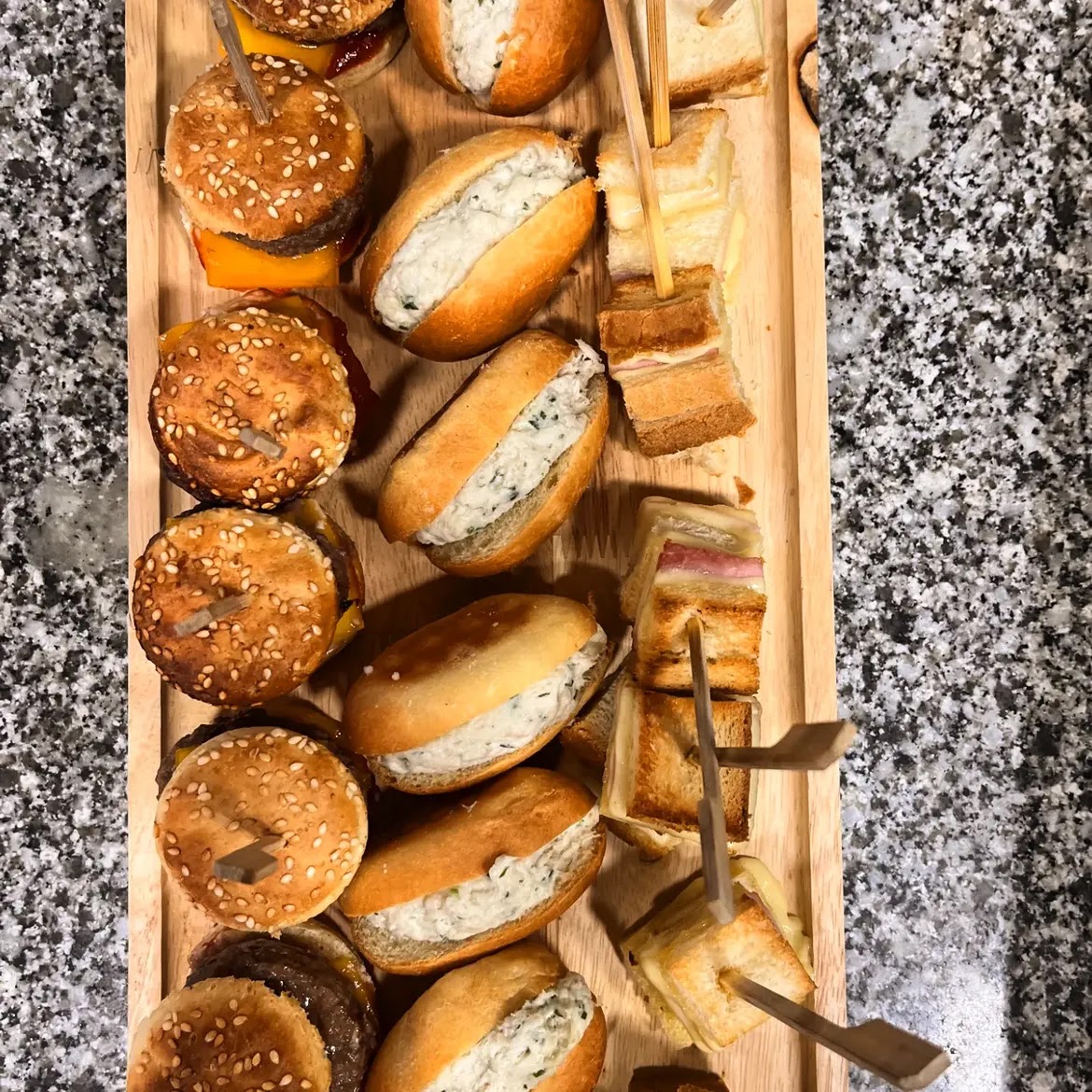 Plateau de mini-sandwichs et sliders assortis sur planche en bois