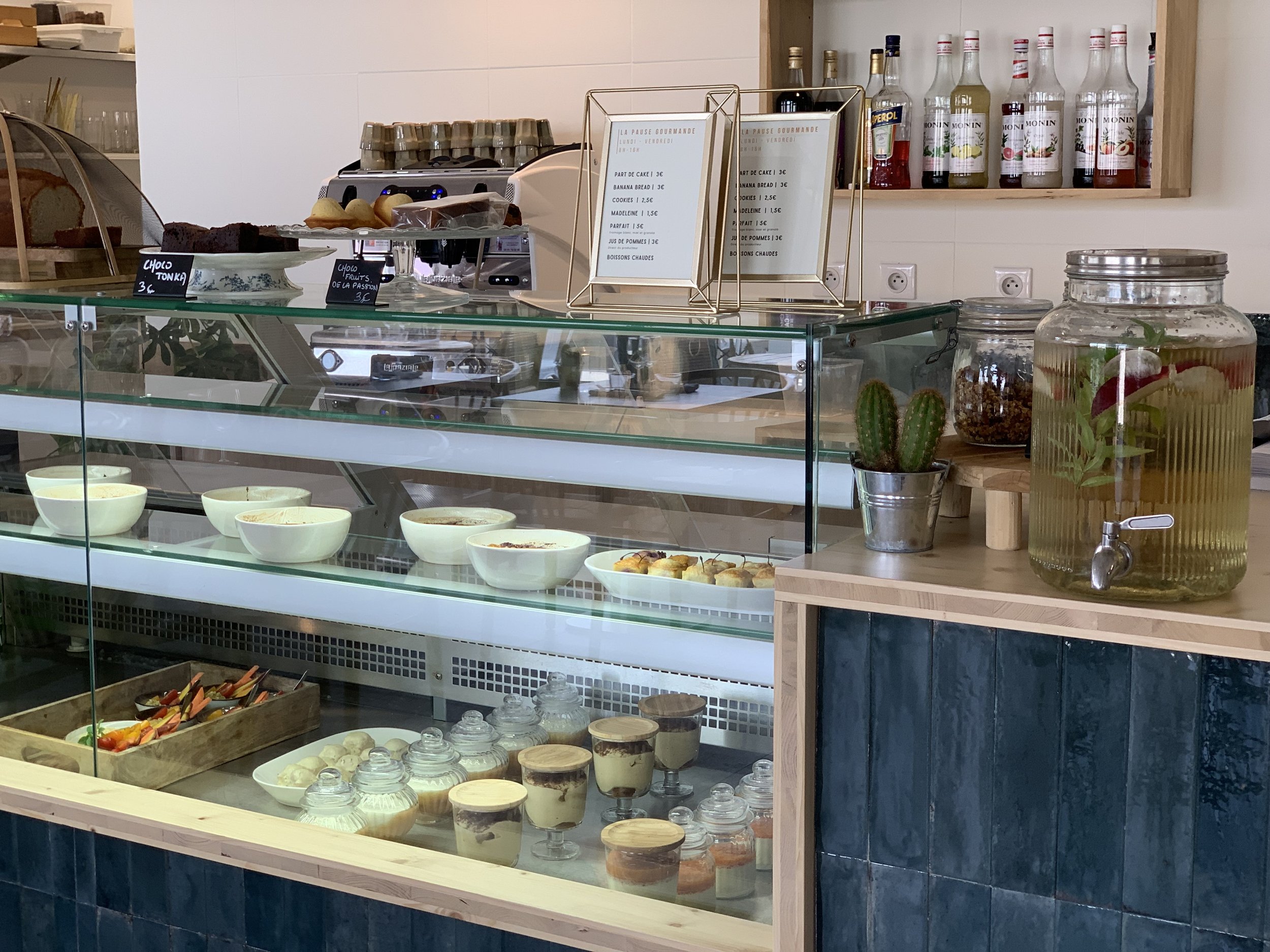 Vitrine réfrigérée d'une pâtisserie café avec desserts et boissons infusées
