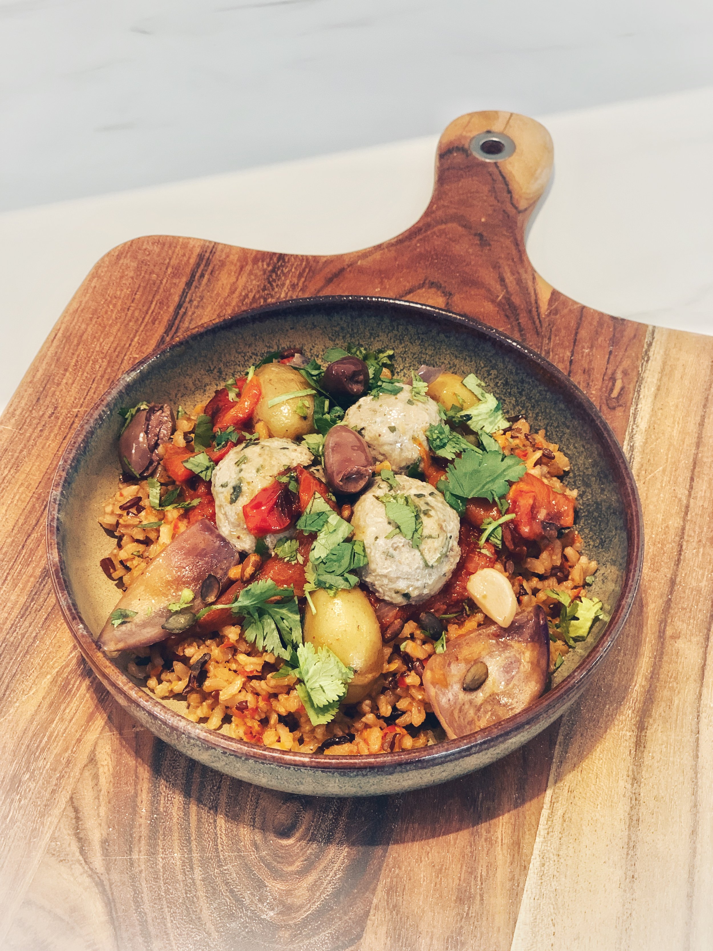 Boulettes aux herbes sur riz épicé avec légumes, olives et pommes de terre